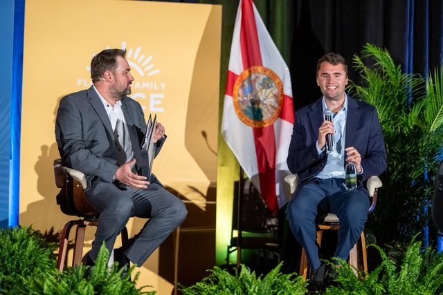 Erik Dellenback seated on stage in conversation with Charlie Kirk at a Florida Family Voice event