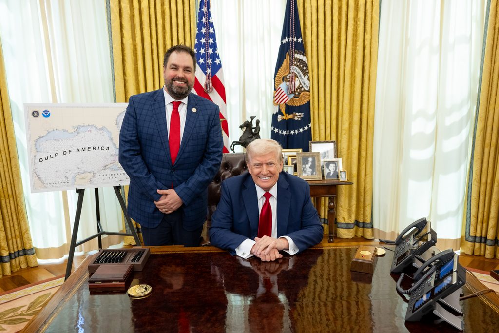 Erik Dellenback standing beside President Trump at the Resolute Desk in the Oval Office